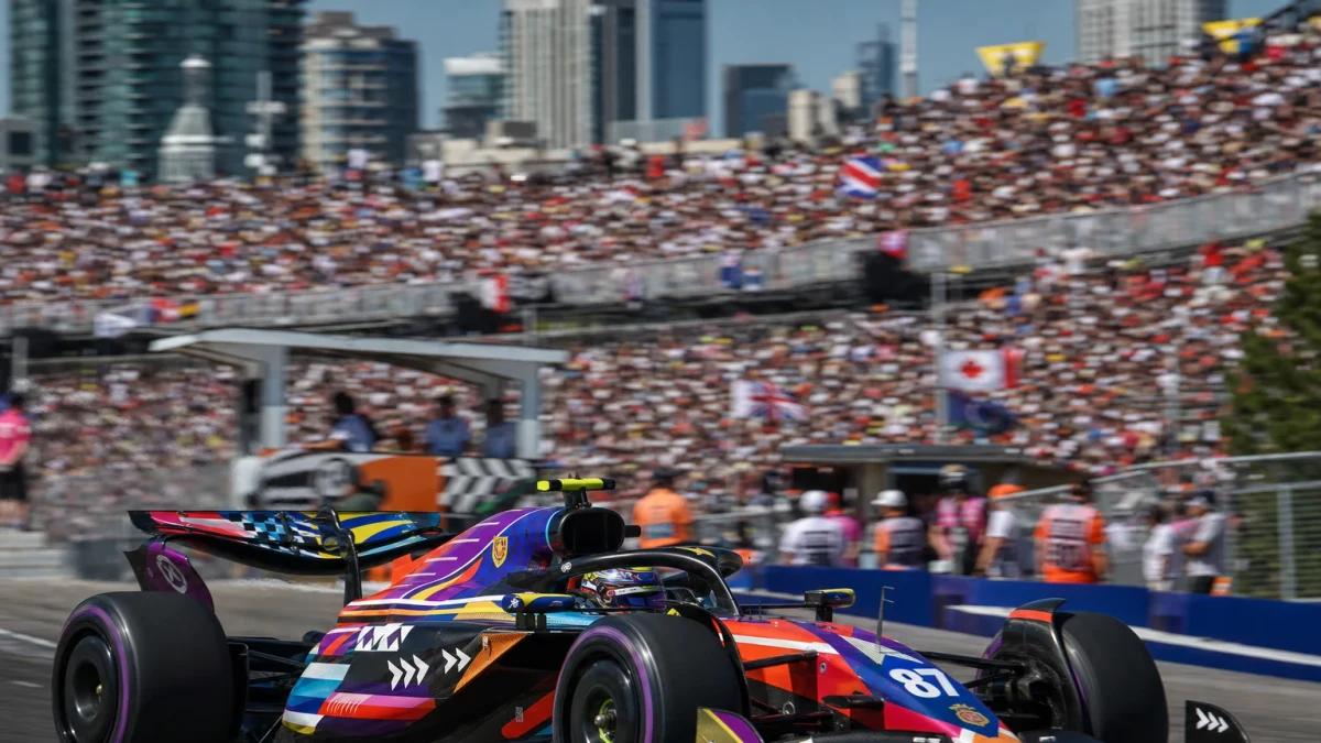 Formel 1-bil i silverfärgad design i ledning på en solig bana under en tävlingshelg.